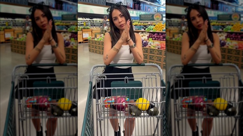 Janel Parrish resting her elbows on a shopping cart.