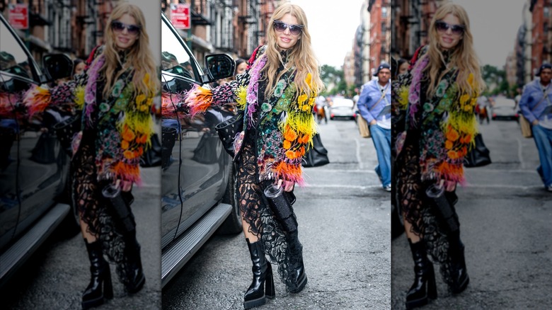 Jessica Simpson wearing a multicolored feathered jacket and black lace dress.