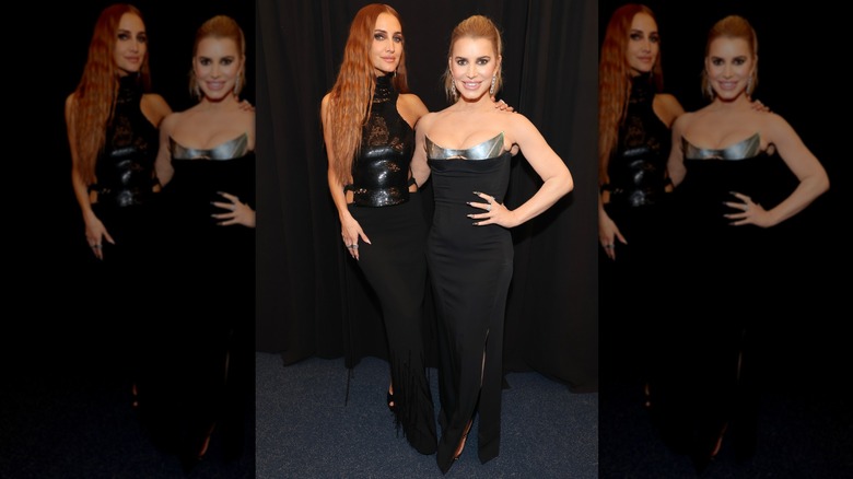 Ashlee and Jessica Simpson posing in black dresses.