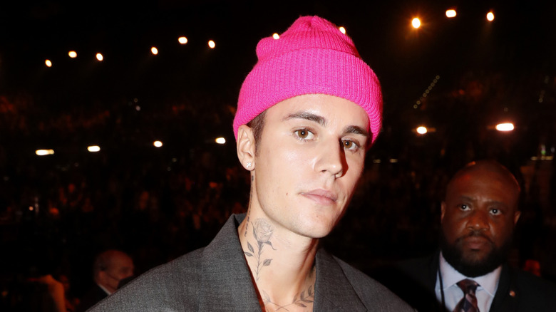 Justin Bieber posing in a bright pink beanie