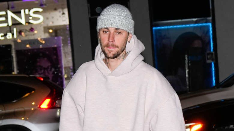 Justin Bieber looking tired as he walks across a street