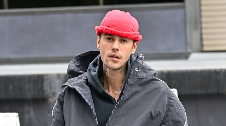 Justin Bieber looking dazed in a red hat and oversized jacket