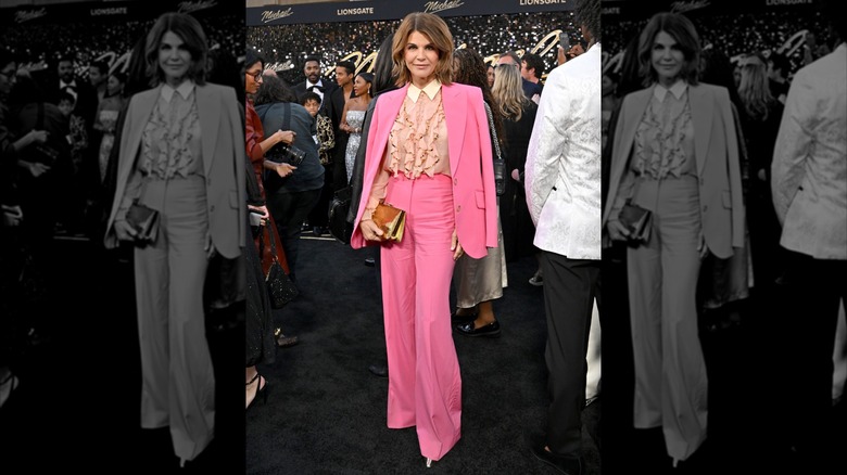 Lori Loughlin posing at formal event among crowd in a pink suit