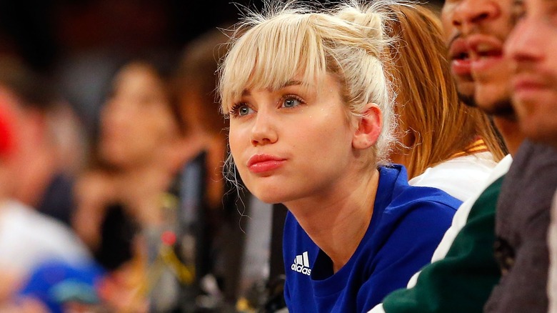 Miley Cyrus looking bored at a sports game in 2016