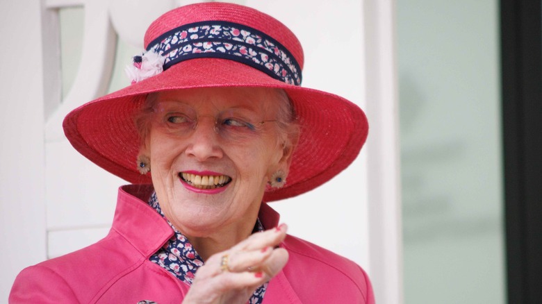 Queen Margrethe smiling wearing pink hat