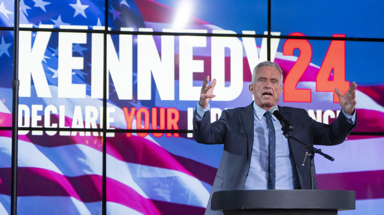 RFK Jr. raising his hands as he addresses a crowd