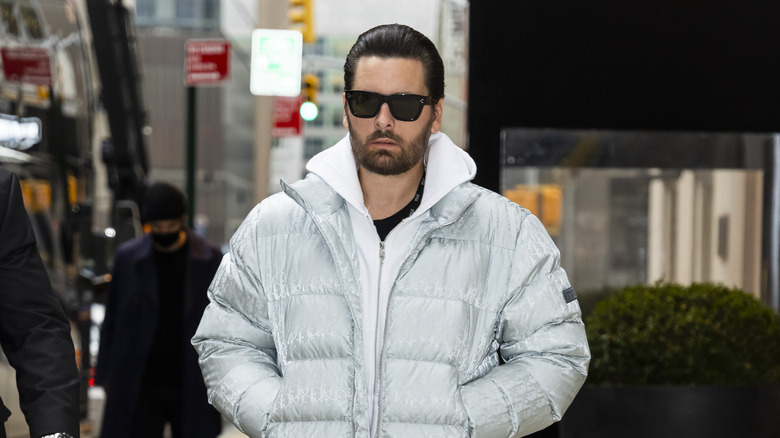 Scott Disick wearing shades and a white coat