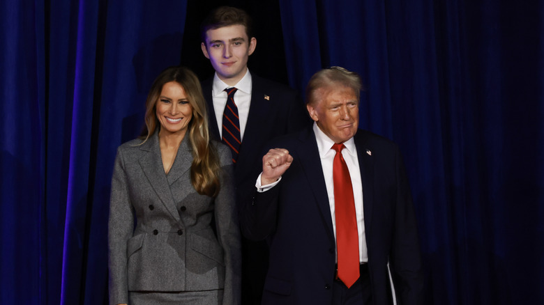 Barron Trump towering over his parents.