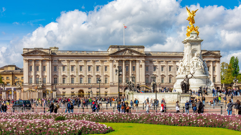 Buckingham Palace seen from its famous tourist entrance, featuring crowds of people visiting it