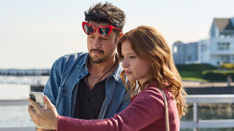 Tyler Hynes and Stacey Farber looking at a phone