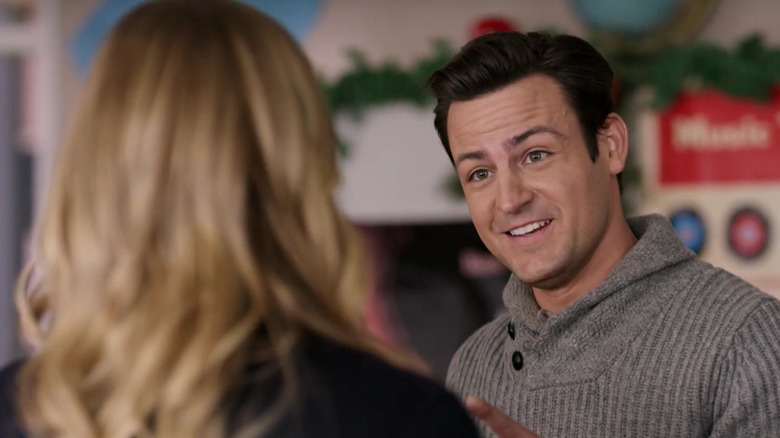 Tyler Hynes smiling and pointing at a blonde woman