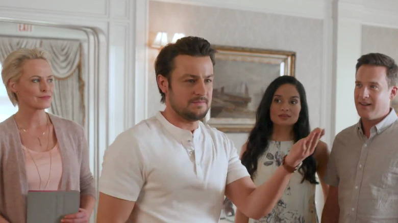 Tyler Hynes gesturing in the middle of a group