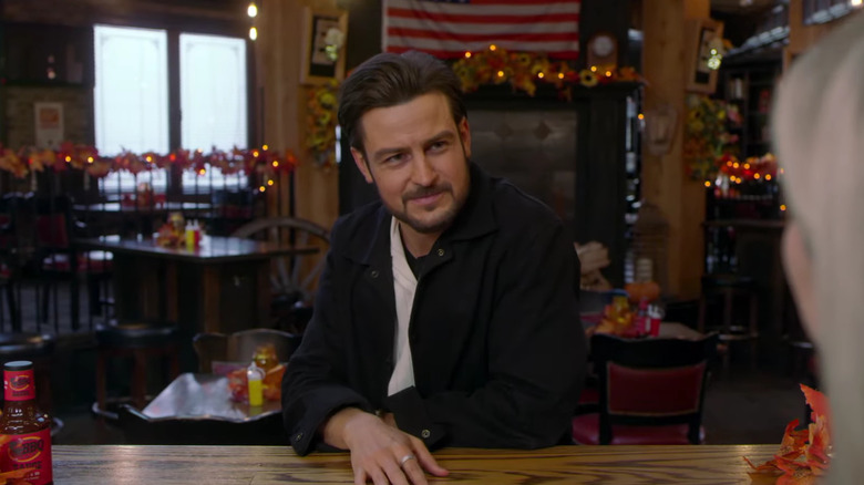 Tyler Hynes with his hand on a table
