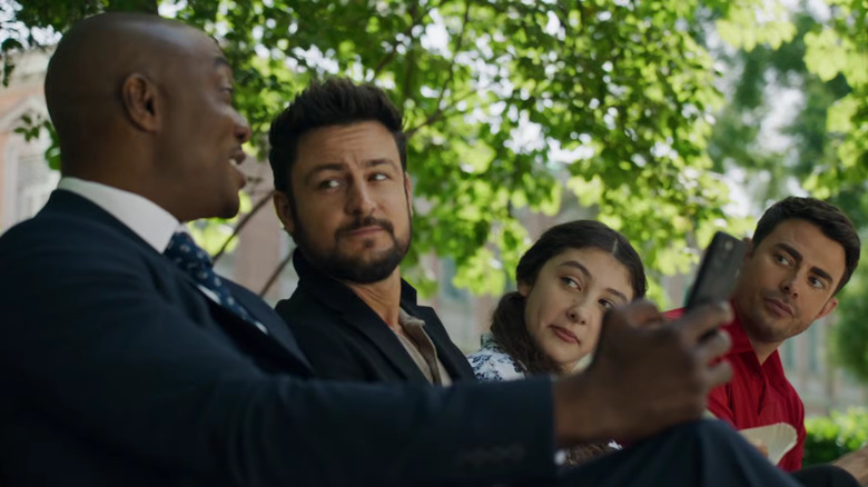B. J. Britt showing his phone to three people, including Tyler Hynes and Jonathan Bennett