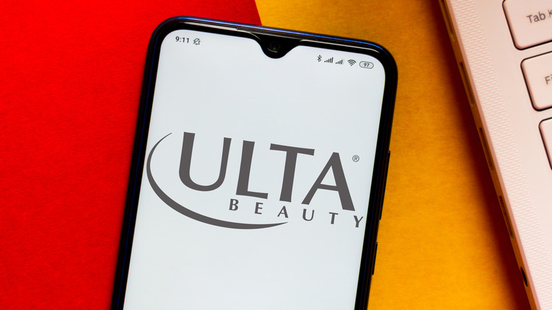 Phone with Ulta Beauty logo next to laptop keyboard