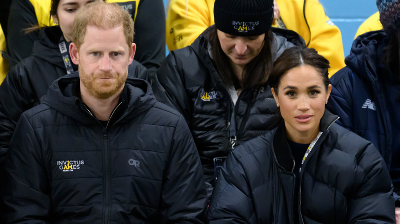 Prince Harry and Meghan Markle with blank stares