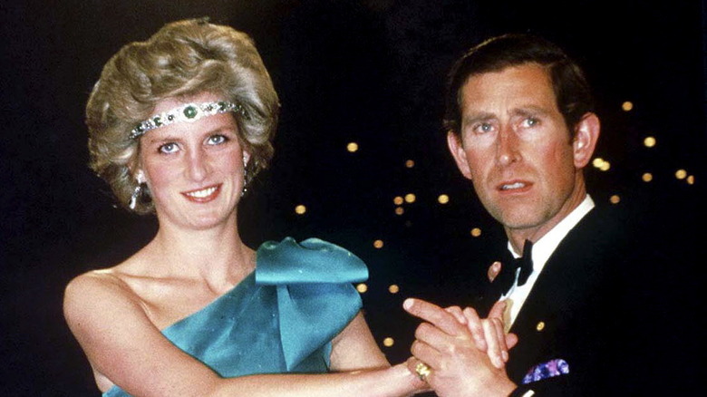 Princess Diana wearing Queen Mary's Asprey halo emerald choker as a headband and dancing with King Charles
