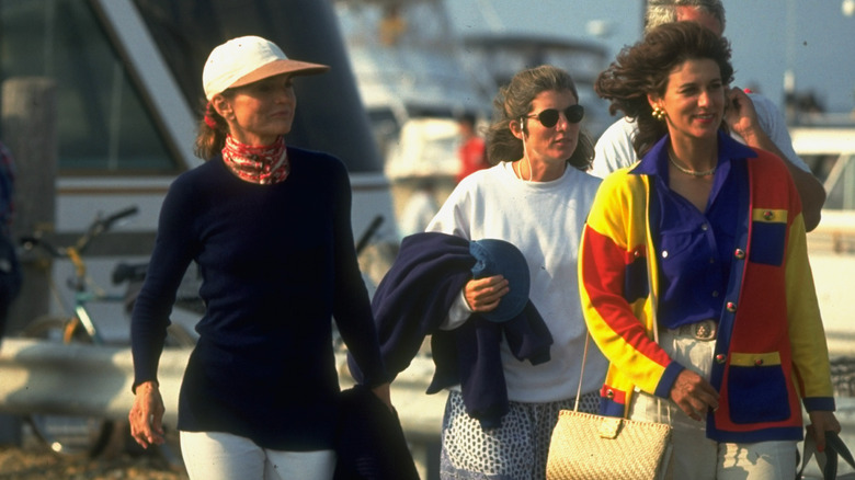 Jackie Kennedy Onassis and Caroline Kennedy walking toward a boat with friends