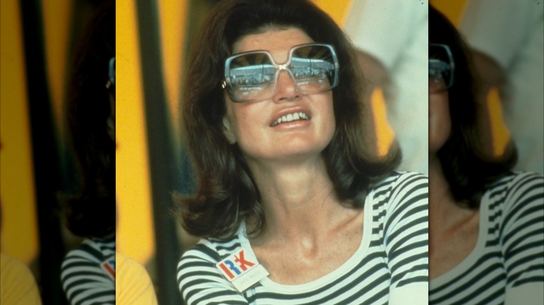 Close-up of Jackie Kennedy Onassis in striped top and large sunglasses