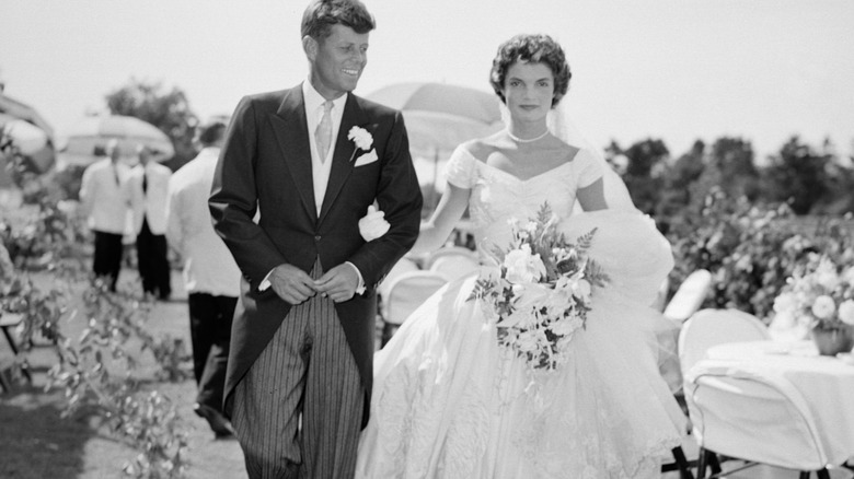 JFK and Jackie Kennedy walking through reception of their wedding
