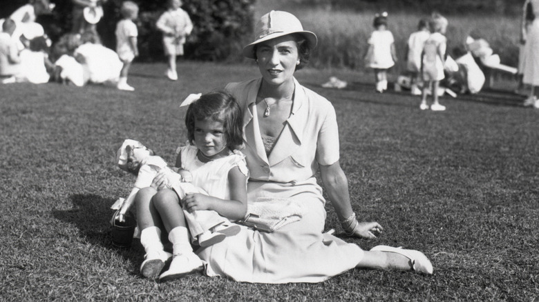 Jackie Kennedy as a child and her mother sitting on grass in the summer