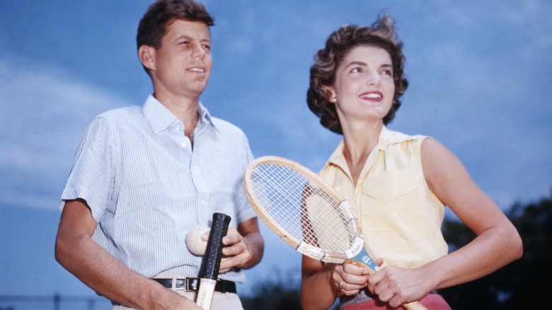 JFK and Jackie Kennedy holding tennis rackets