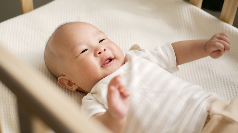 Baby laughing in crib
