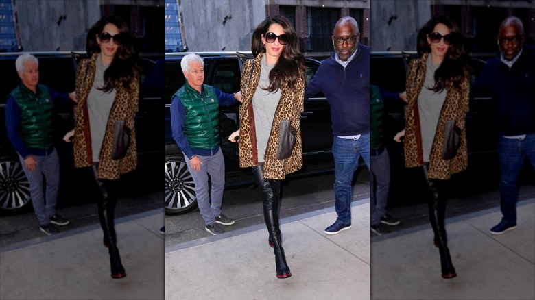 Amal Clooney stepping away from a black car in a cheetah print jacket
