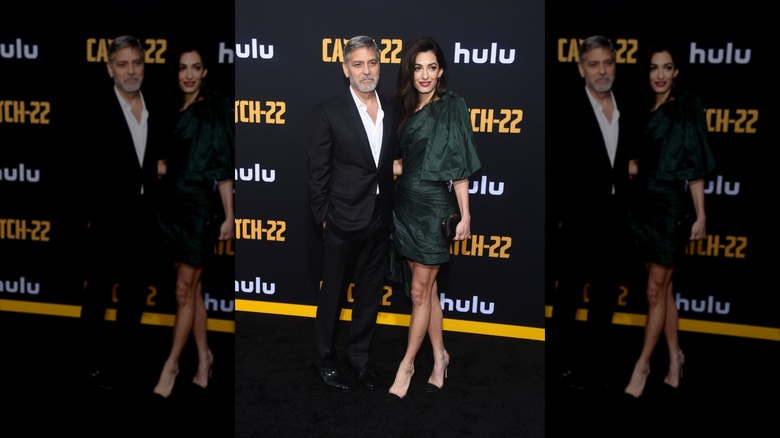 Amal Clooney in a mini dress with husband George Clooney on a premiere carpet.