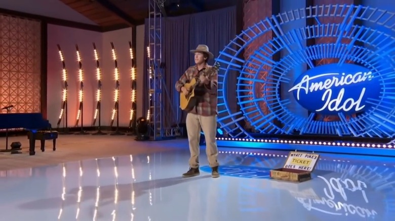 Wyatt Pike playing guitar in front of an American Idol sign, next to a box that says Wyatt Pike's Ticket Goes Here