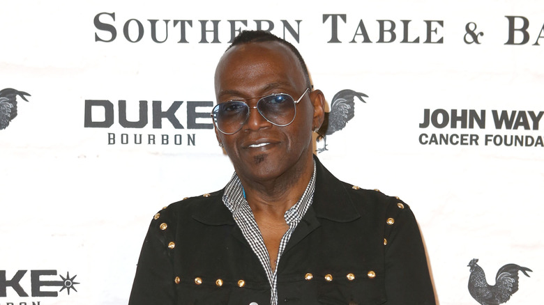 Randy Jackson posing on the red carpet while wearing sunglasses