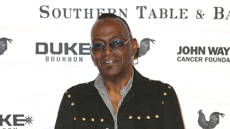 Randy Jackson posing on the red carpet while wearing sunglasses