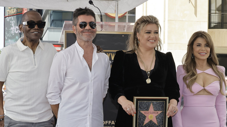"American Idol" judges Randy Jackson, Simon Powell, Kelly Clarkson and Paula Abdul smiling while posing together