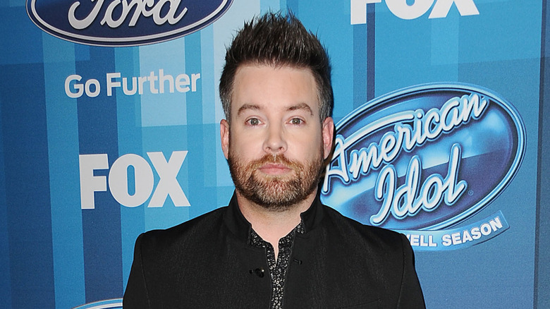 David Cook posing in front of American Idol signage