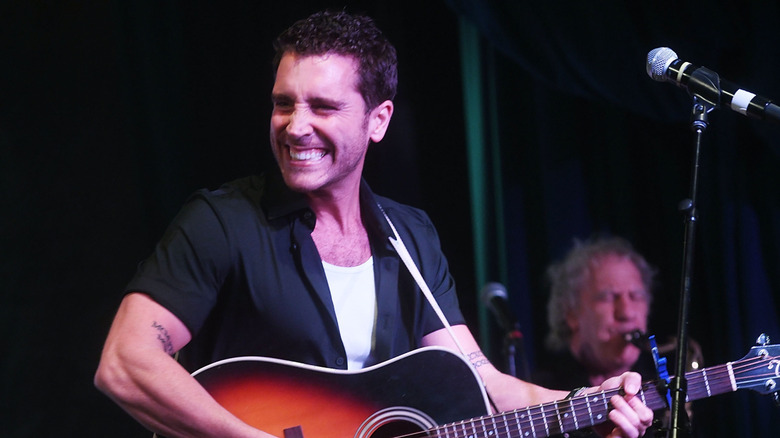 Nick Fradiani playing guitar on stage