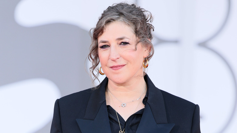 Mayim Bialik posing and smiling on red carpet at Venice Film festival.