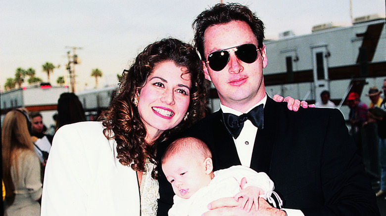 Amy Grant, Gary Chapman, and their daughter smiling and posing at a formal event