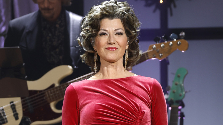 Amy Grant smiling while performing at the Ryman Auditorium in 2022