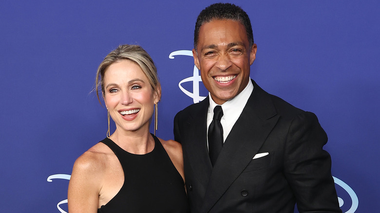 Amy Robach and TJ Holmes smiling at event