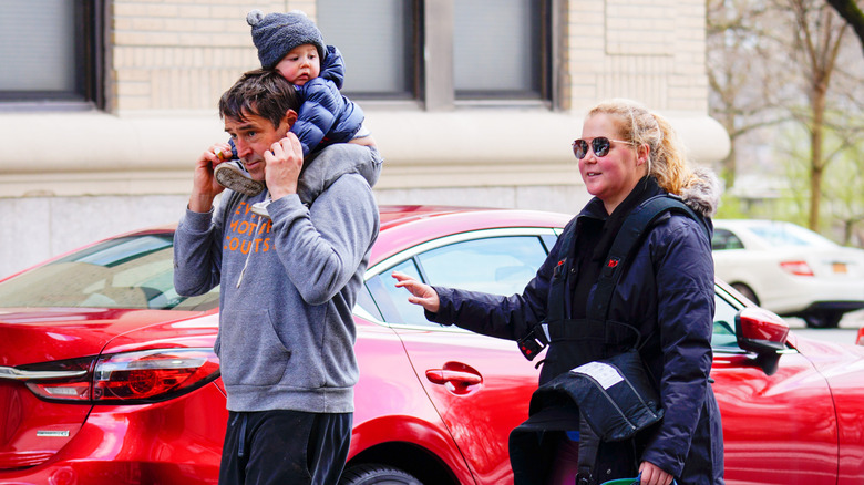 Chris Fischer and Amy Schumer walking with their son Gene