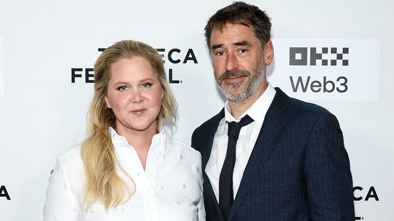 Amy Schumer and Chris Fischer smirking