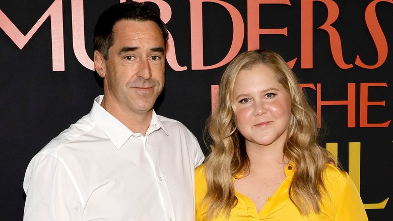 Chris Fischer and Amy Schumer smirking