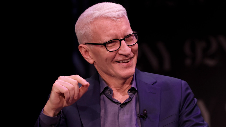 Anderson Cooper smiling with a book