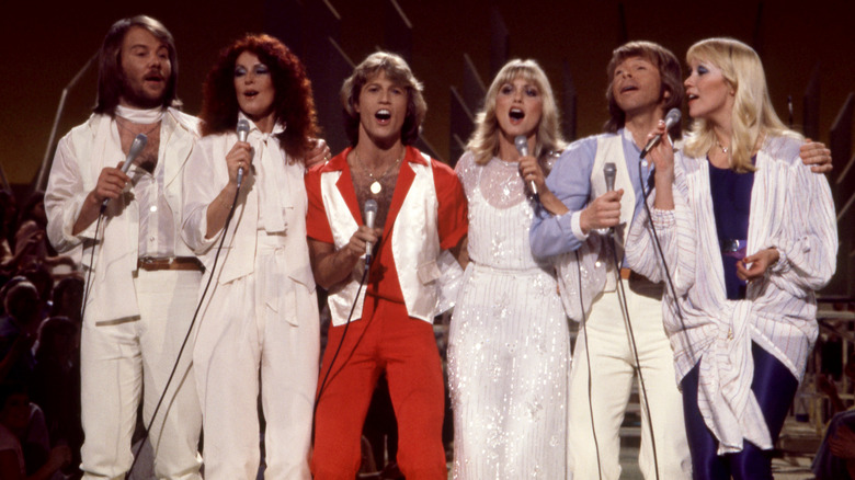 Andy Gibb (in red) performing with ABBA and Olivia Newton-John