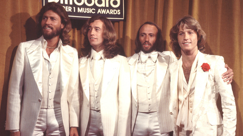 The Gibb brothers posing in white suits at the Billboard Music Awards, from left: Barry, Robin, Maurice, and Andy Gibb