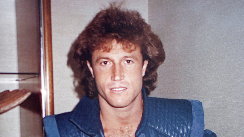 Andy Gibb posing for a photo (circa 1985) in a blue shirt