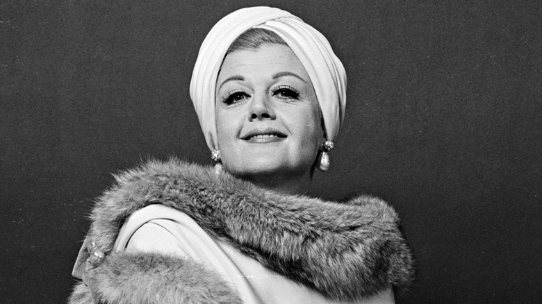 A black and white photo of Angela Lansbury wearing fur and a white headscarf