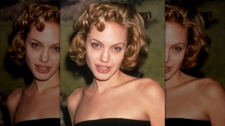 American actor Angelina Jolie attends an event wearing a strapless black gown, New York City, circa 1999