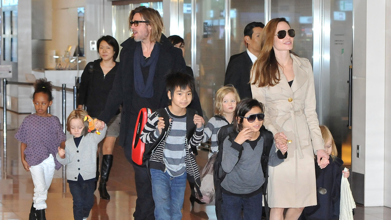 Brad Pitt, Angelina Jolie and their six children Zahara, Knox, Pax, Shiloh, Maddox, and Vivienne walking through Haneda International Airport