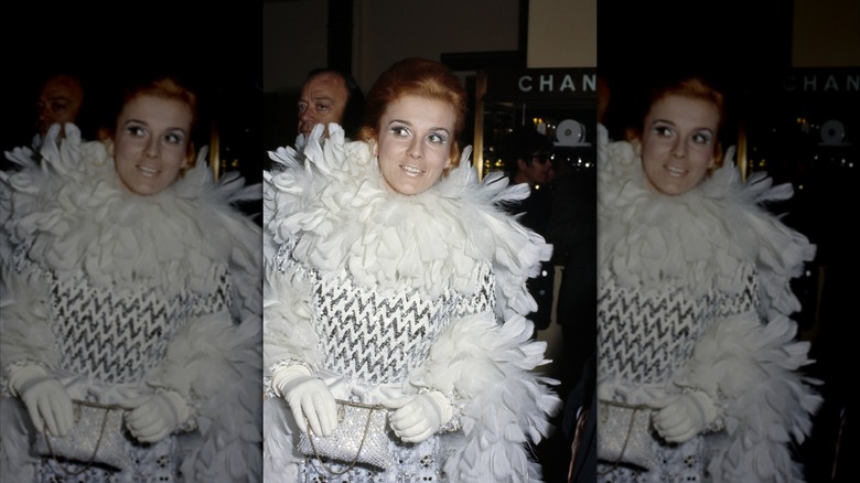Ann-Margret in a silver and white dress, with a white feather boa and white gloves
